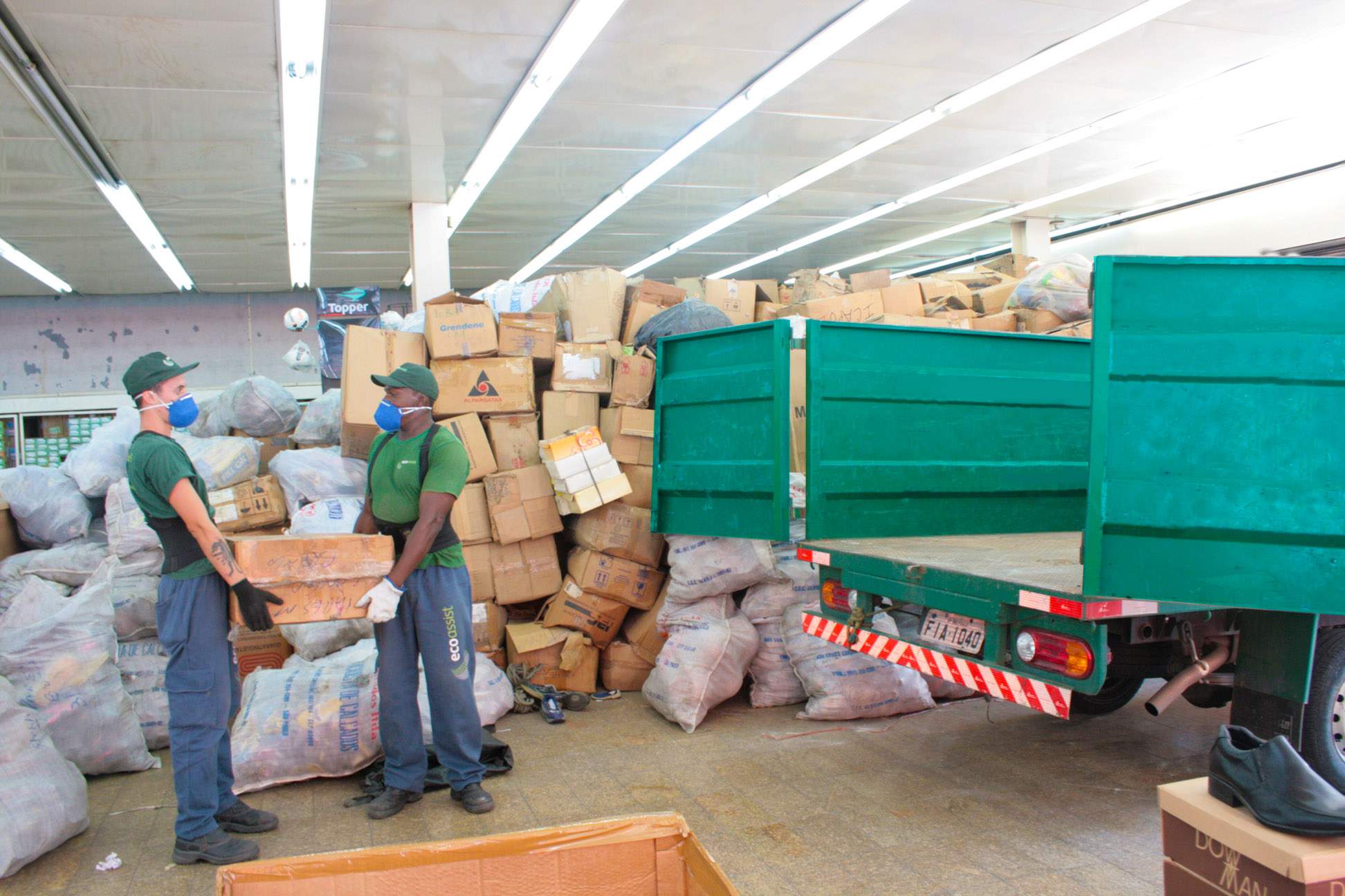 Equipe Ecoassist carregando uniforme de enfermagem em caixas para um caminhão