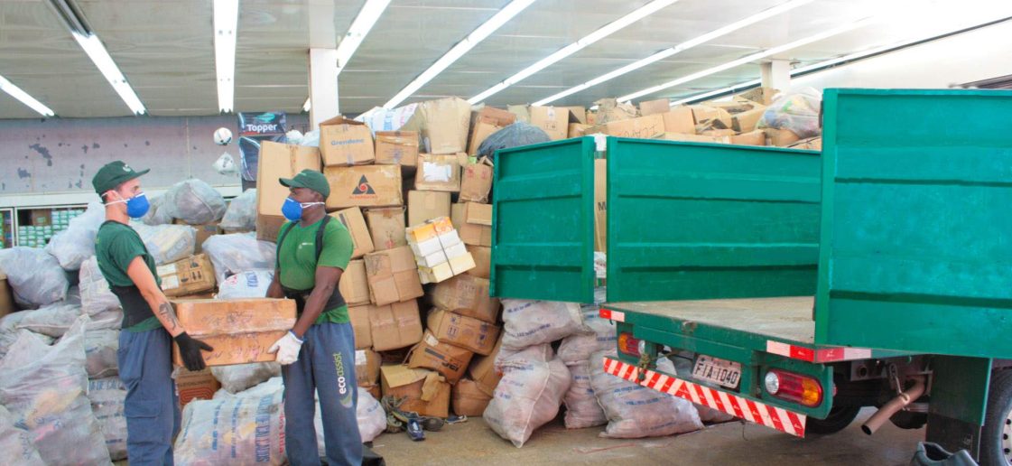 Equipe Ecoassist carregando uniforme de enfermagem em caixas para um caminhão