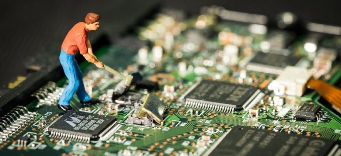 porque você não pode consertar o seu celular Ecoassist Obsolescência Programada. #ParaTodosVerem um celular aberto com vários chips e um homem em miniatura dentro do celular com um machado quebrando o celular.